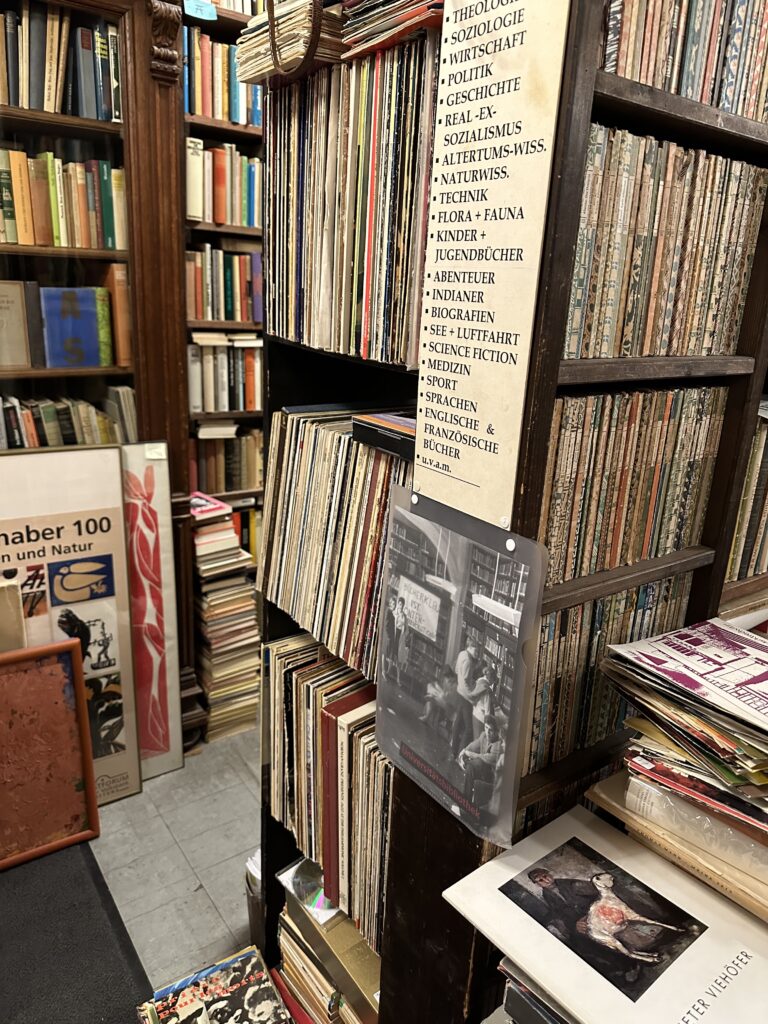 a photo of a bookshelf in a berlin shop with a sign in german listing organization categories